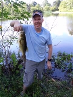 A photo of my friend John showing a fish he caught fishing.
