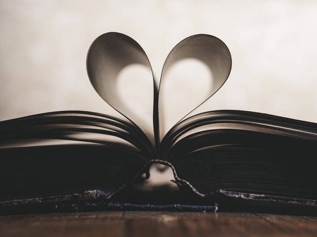 Photo of a bible and its page are folded like a heart.